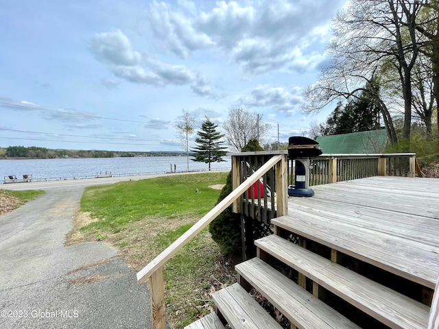 wooden deck featuring a yard and a water view