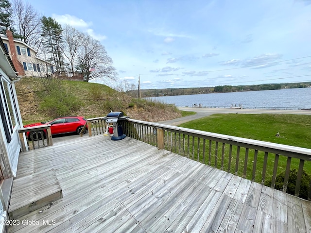 deck with a lawn and a water view