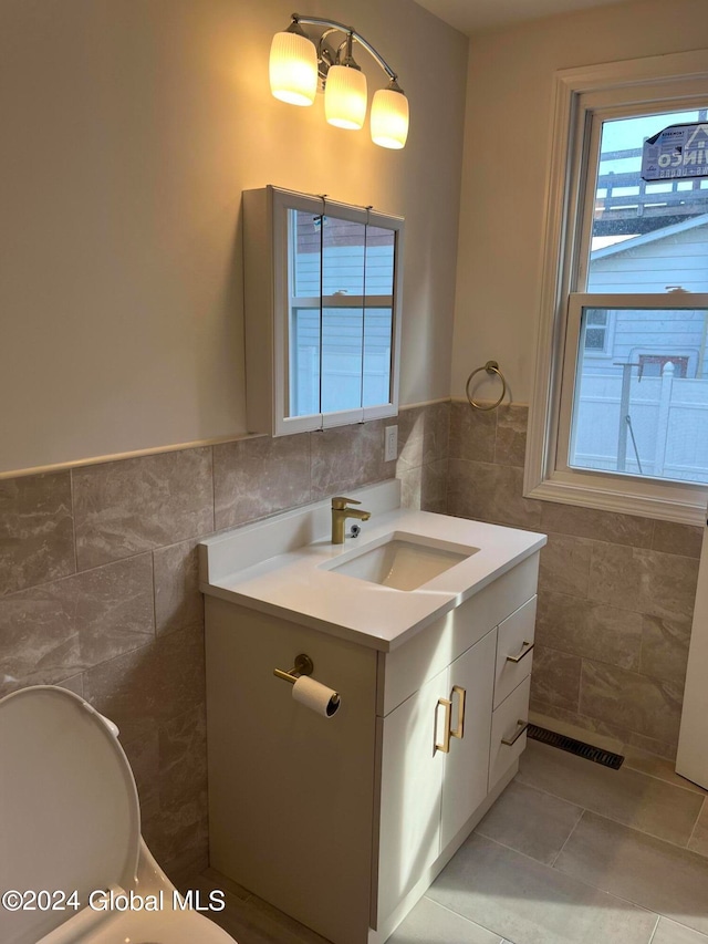 bathroom with tile walls, vanity, and a wealth of natural light