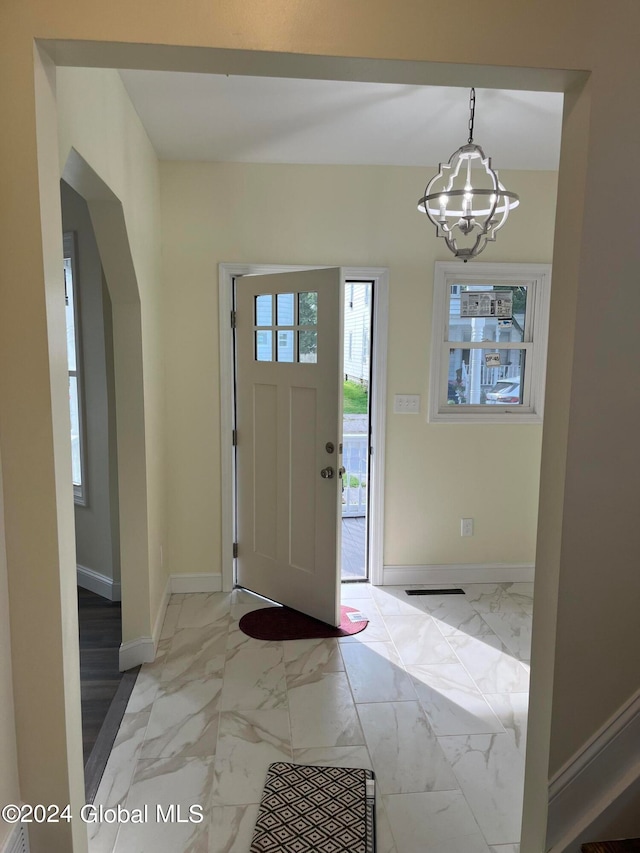 foyer entrance with a notable chandelier