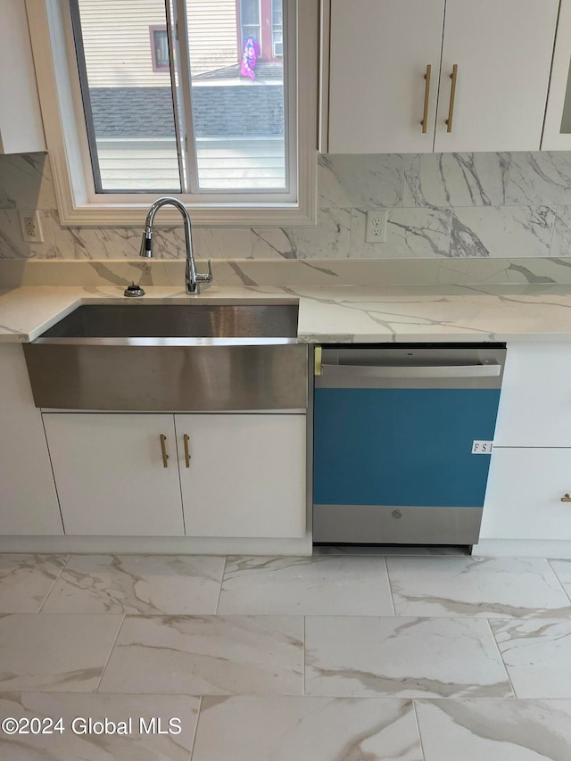 kitchen featuring a healthy amount of sunlight, dishwasher, sink, and light stone countertops