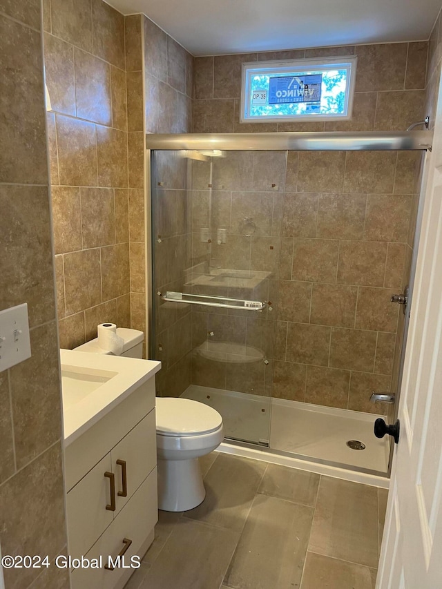 bathroom featuring tile walls, vanity, walk in shower, tile patterned flooring, and toilet