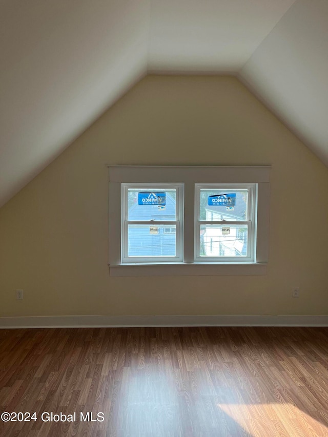 additional living space with hardwood / wood-style flooring, lofted ceiling, and a wealth of natural light