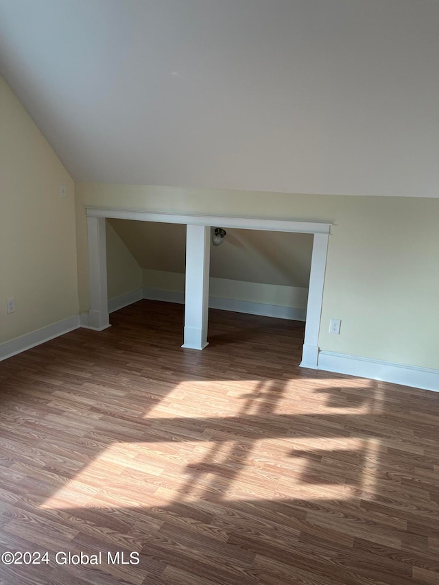 empty room with hardwood / wood-style flooring and lofted ceiling