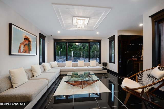 living room with an inviting chandelier and dark tile patterned flooring