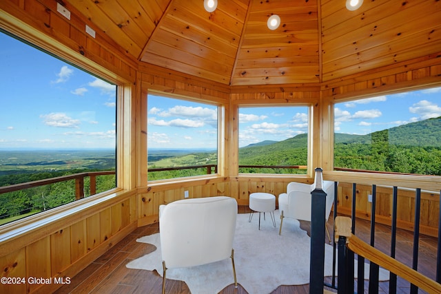 sunroom featuring a mountain view, lofted ceiling, and wood ceiling