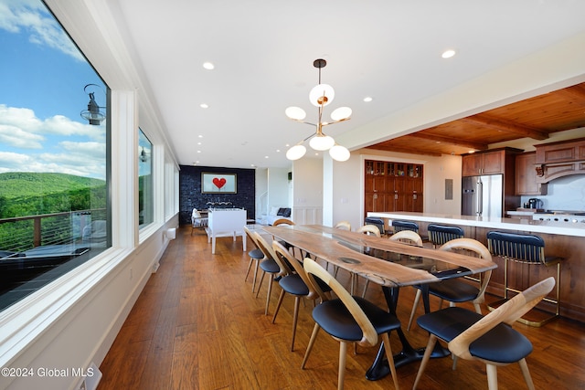 dining area featuring beamed ceiling, a chandelier, wooden ceiling, and dark hardwood / wood-style floors