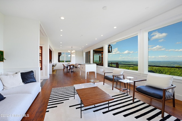 living room featuring hardwood / wood-style flooring, a healthy amount of sunlight, and an inviting chandelier