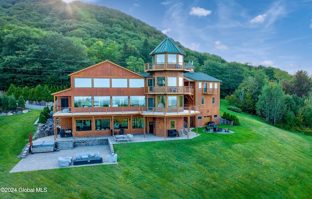 rear view of house featuring a patio, a yard, and an outdoor hangout area