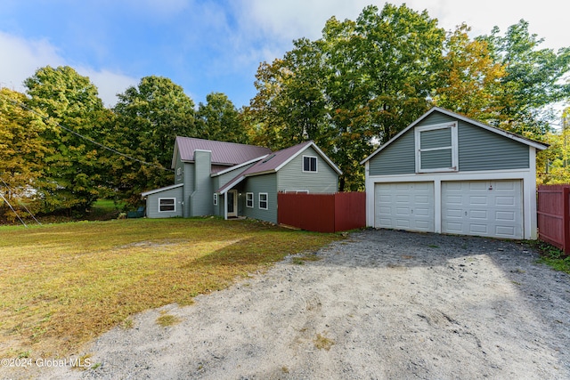 view of front property featuring an outbuilding, a garage, and a front lawn