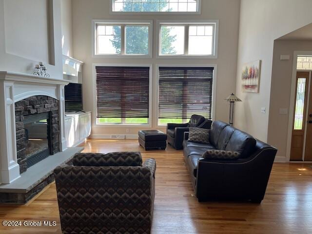 living room featuring a fireplace, hardwood / wood-style floors, and a high ceiling