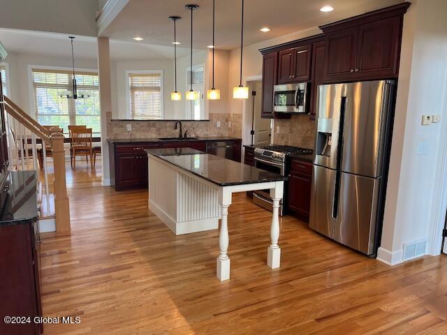 kitchen featuring a healthy amount of sunlight, stainless steel appliances, and light wood-type flooring