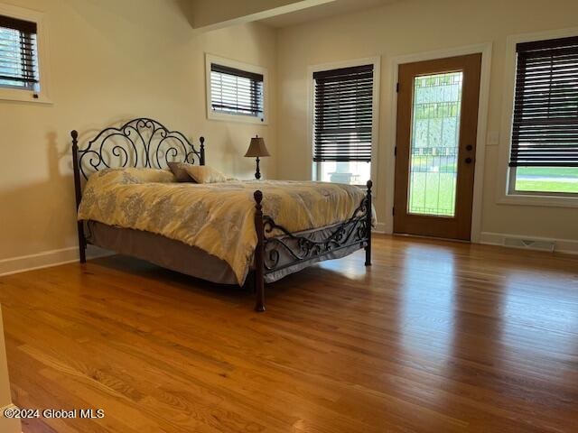 bedroom featuring hardwood / wood-style floors, multiple windows, and access to outside