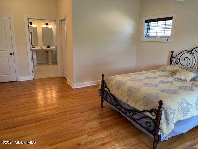 bedroom featuring ensuite bathroom and light hardwood / wood-style floors