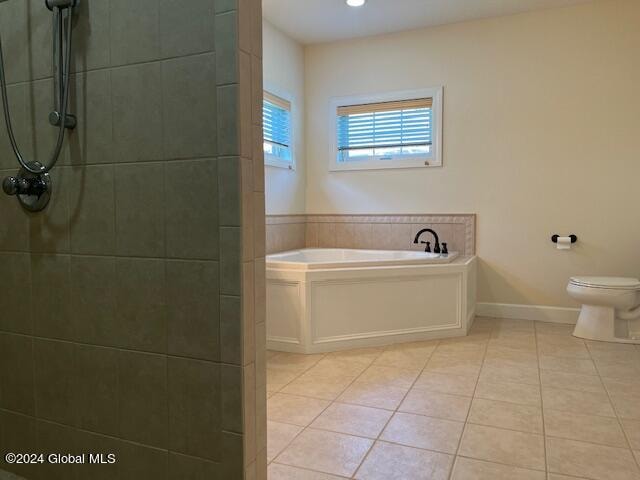 bathroom featuring toilet, independent shower and bath, and tile patterned floors