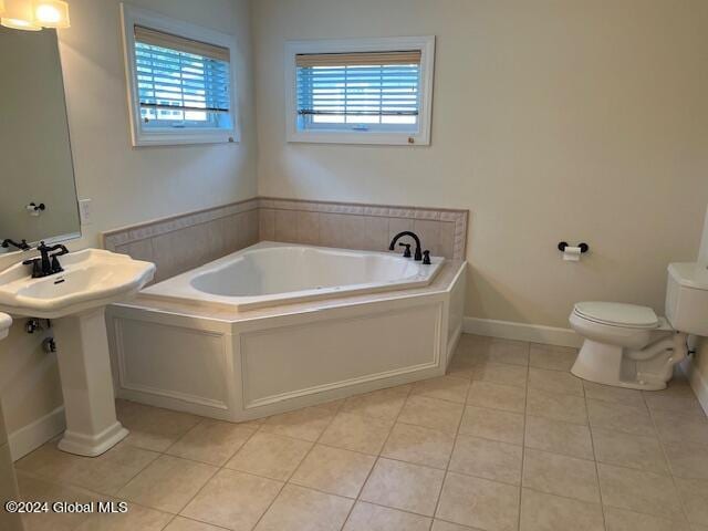 bathroom featuring tile patterned flooring, toilet, and a bath