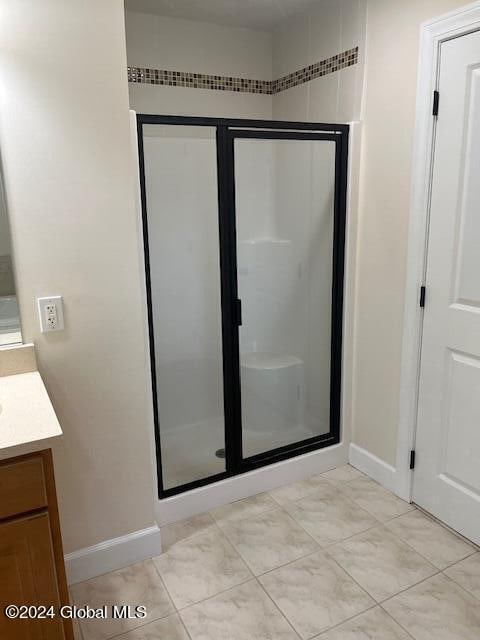 bathroom featuring vanity and a shower with shower door