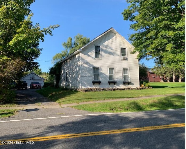 view of front of property featuring a front lawn, an outbuilding, and a garage