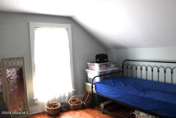 bedroom with hardwood / wood-style flooring and lofted ceiling