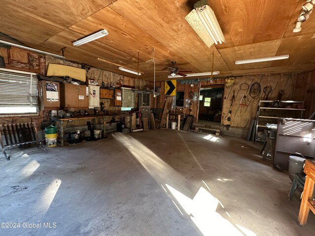 garage featuring wooden ceiling, a workshop area, and ceiling fan