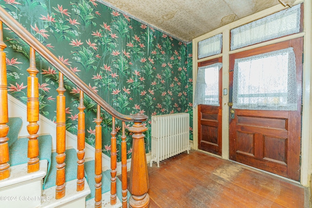 entrance foyer with wood-type flooring and radiator heating unit