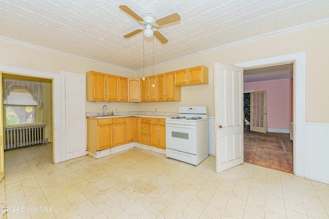 kitchen featuring radiator, sink, ornamental molding, ceiling fan, and white range with gas stovetop