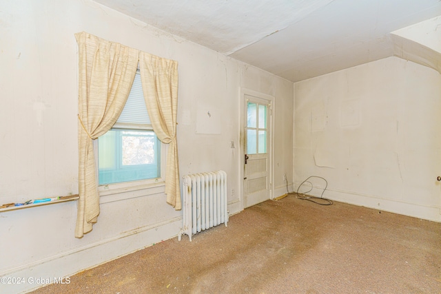 carpeted empty room with radiator heating unit