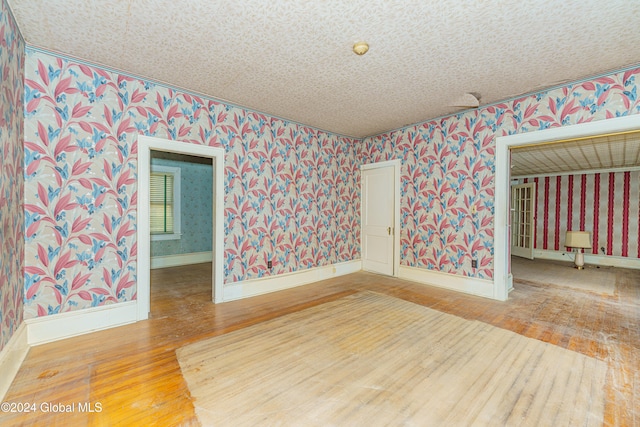 empty room featuring wood-type flooring and a textured ceiling