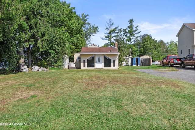 view of front facade featuring a front yard and a storage unit