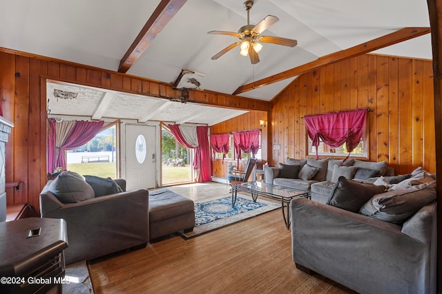 living room with wooden walls, lofted ceiling with beams, ceiling fan, and wood-type flooring