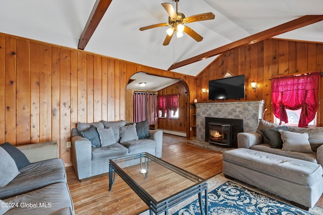 living room with vaulted ceiling with beams, wood walls, and ceiling fan