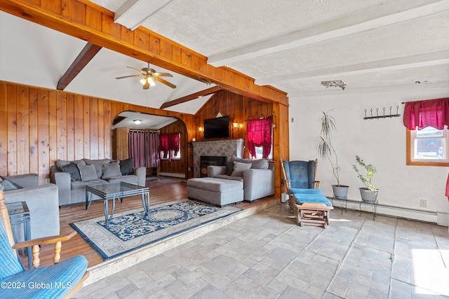 living room with ceiling fan, wood walls, a textured ceiling, lofted ceiling with beams, and a baseboard radiator