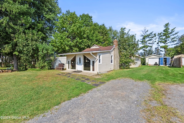 view of front facade featuring an outdoor structure, a garage, and a front lawn