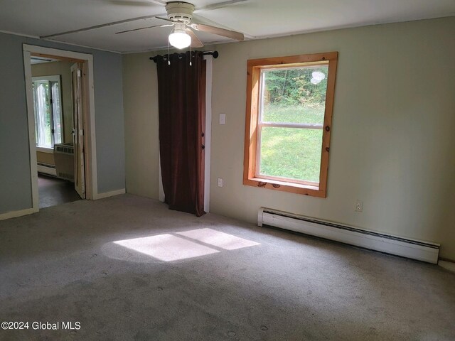 carpeted empty room with ceiling fan and baseboard heating