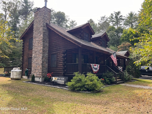 view of side of home featuring a yard and covered porch