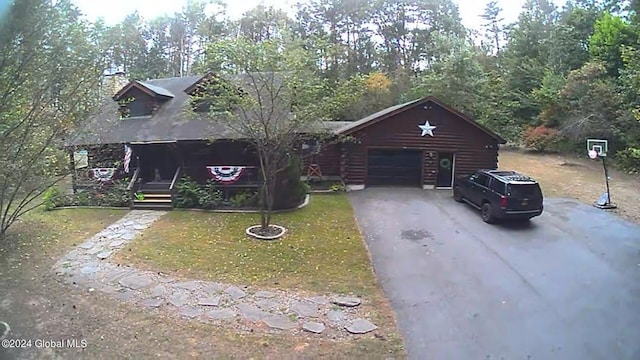 log cabin with a garage and a front lawn