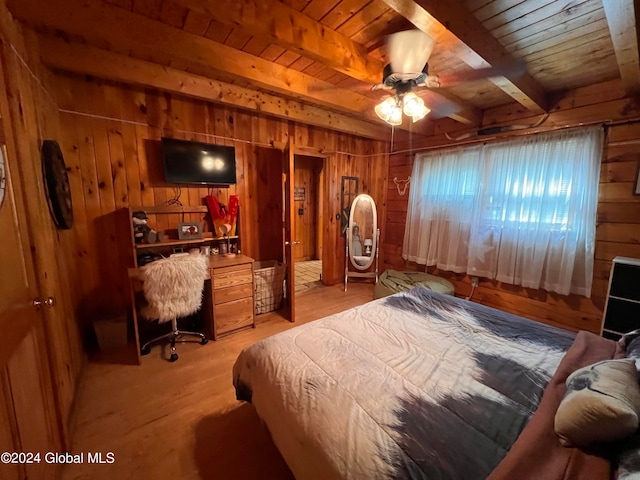 bedroom featuring wooden walls, beam ceiling, light hardwood / wood-style floors, and wooden ceiling