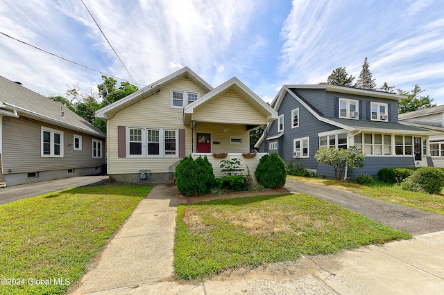 view of front of house featuring covered porch and a front lawn