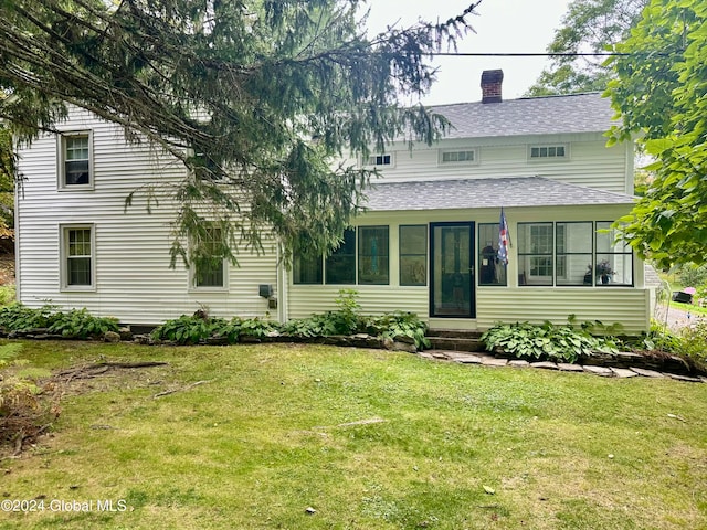 view of front facade with a sunroom and a front yard