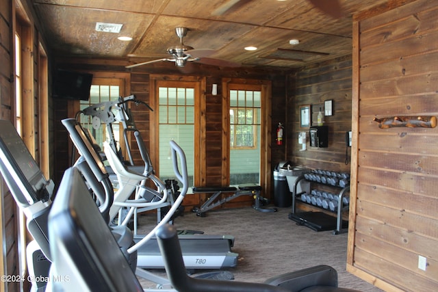 workout room with carpet floors, wood ceiling, wooden walls, and ceiling fan