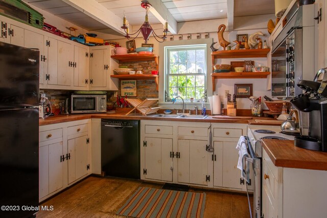 kitchen featuring hanging light fixtures, white cabinets, black appliances, wood-type flooring, and sink