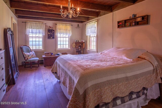 bedroom featuring wood-type flooring, beamed ceiling, an inviting chandelier, and wooden ceiling