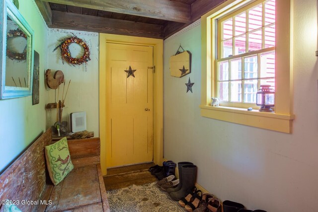 entryway featuring a healthy amount of sunlight, beam ceiling, and heating unit