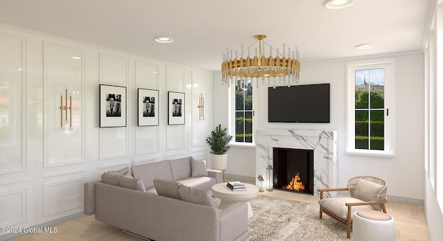 living room with ornamental molding, an inviting chandelier, and a high end fireplace