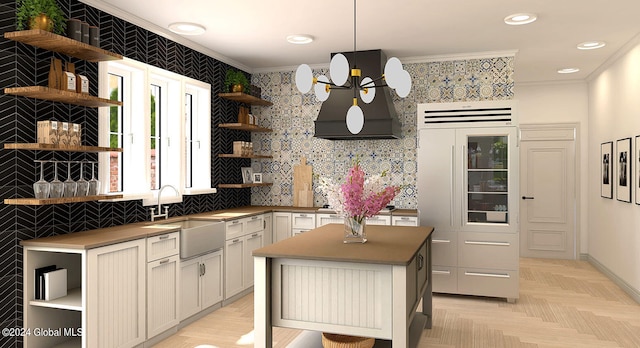 kitchen featuring crown molding, a kitchen island, sink, and pendant lighting