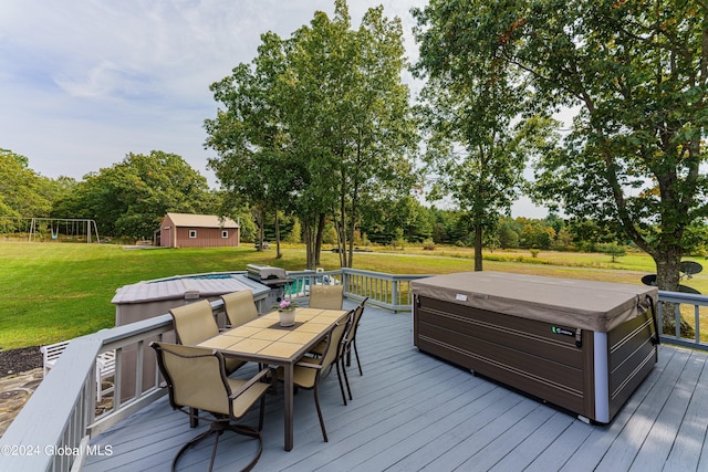 deck featuring a trampoline, a yard, and a hot tub