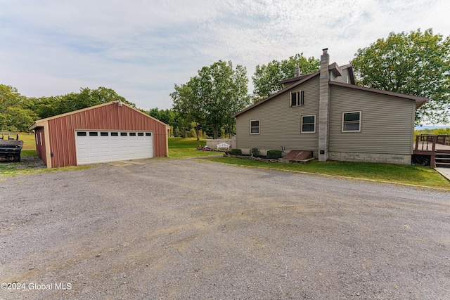 view of side of home with a garage, an outdoor structure, and a wooden deck