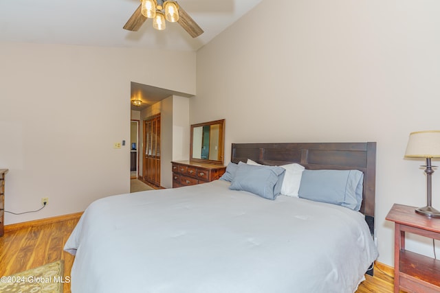 bedroom with vaulted ceiling, ceiling fan, and light hardwood / wood-style flooring