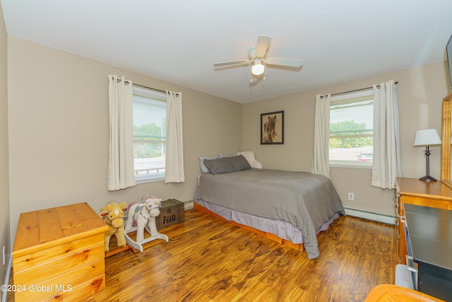 bedroom featuring multiple windows, dark hardwood / wood-style flooring, ceiling fan, and a baseboard radiator