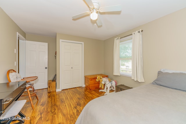 bedroom with wood-type flooring, ceiling fan, and a closet